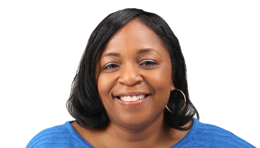 A corporate professional smiles as she's photographed in a blue top